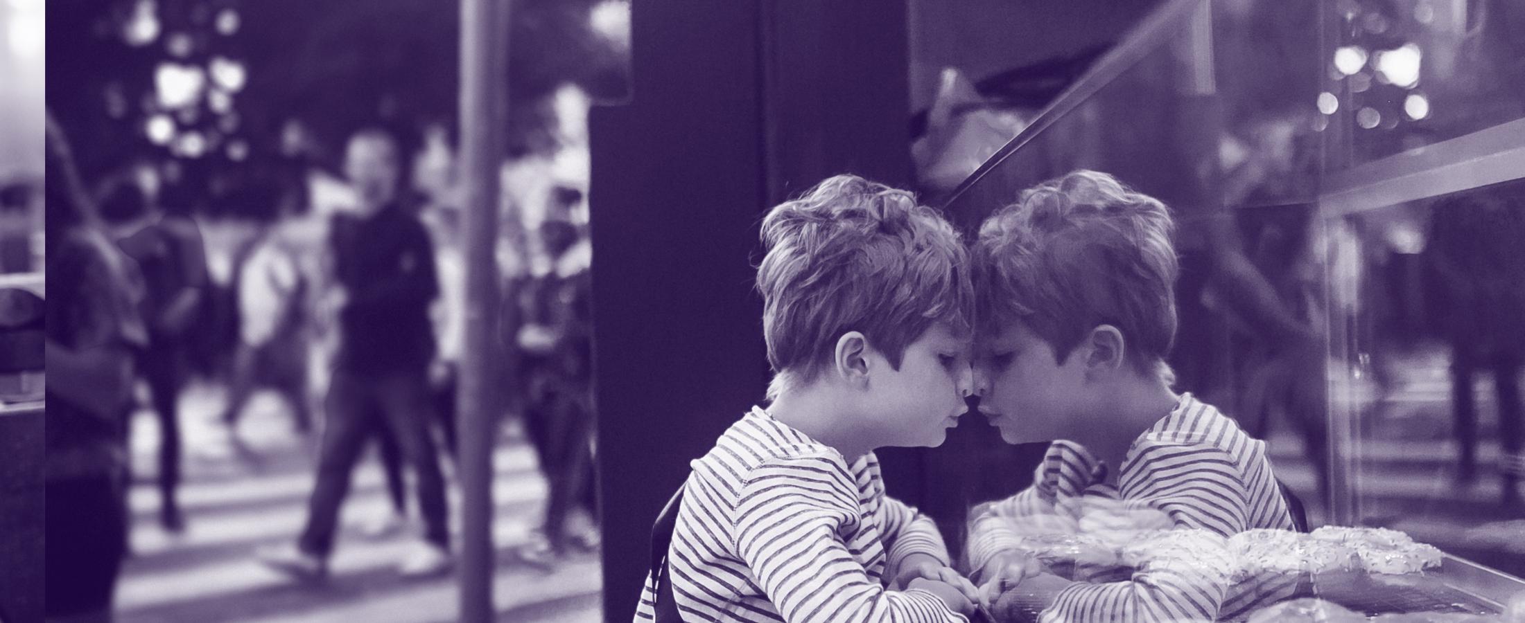 young boy staring at pastry store